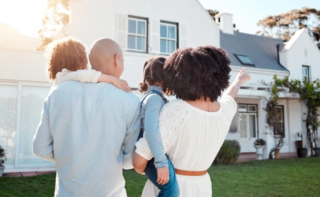 Happy family standing in front of their new home